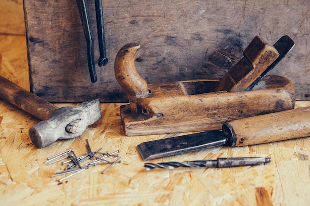 Старые строительные инструменты на деревянном верстаке плоские лежали фон. стол плотник. изделия из дерева