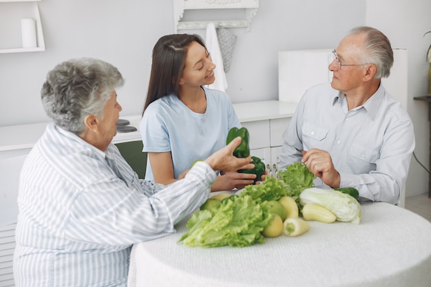 Old couple in a kitchen with young granddaughter