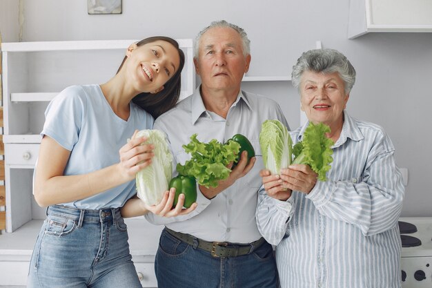 Old couple in a kitchen with young granddaughter