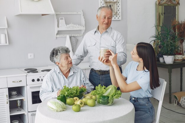 Old couple in a kitchen with young granddaughter