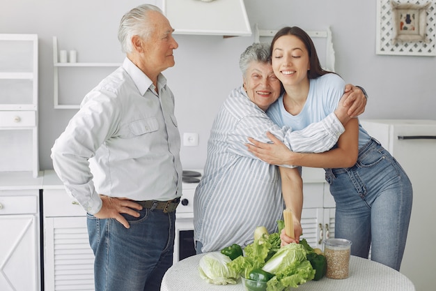 Old couple in a kitchen with young granddaughter