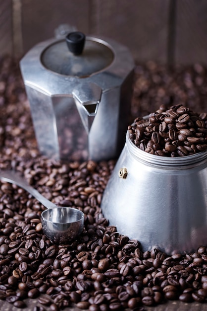 Old fashioned coffee mill and spoon among coffee bean