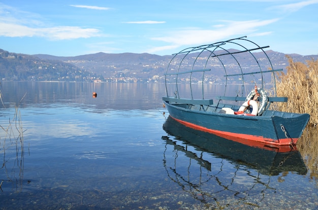 Free photo old fishing boat in the lake with mountains