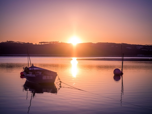 夕日の息をのむような景色を望む川での古い漁船