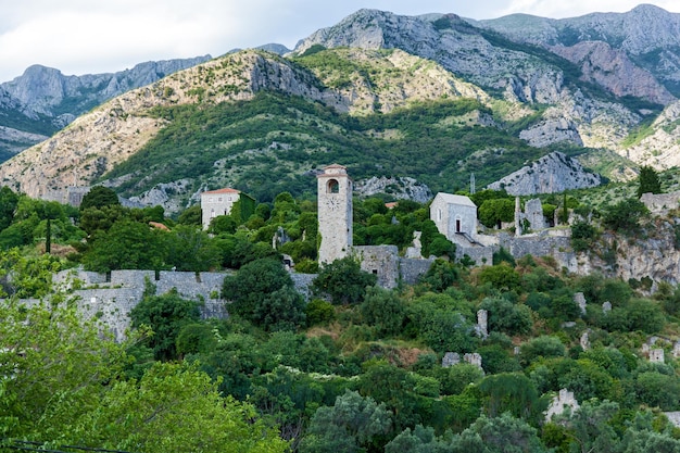 Old fortress clock tower on the background of mountains in the city of bar montenegro