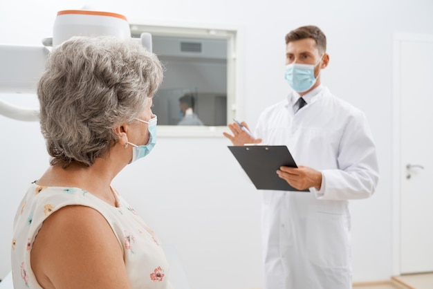 Free photo old grey haired female in cabinet in modern clinic