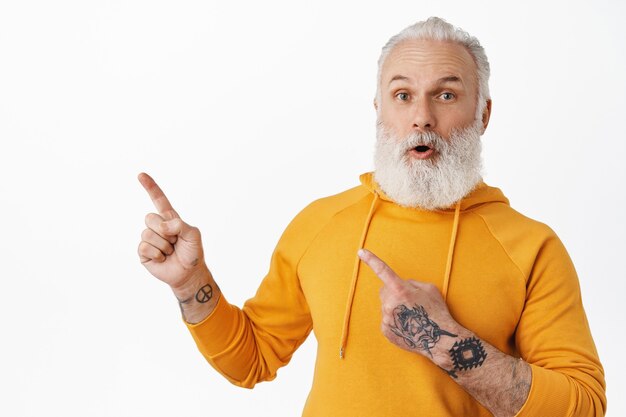 Old guy with tattoos and long beard asking question about logo product, white wall