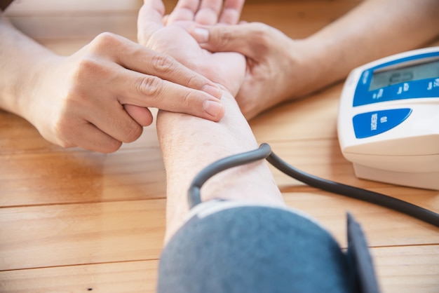 Free photo old lady is being checked blood pressure using blood pressure monitor kid set