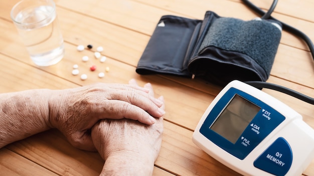 Old lady is being checked blood pressure using blood pressure monitor kid set 