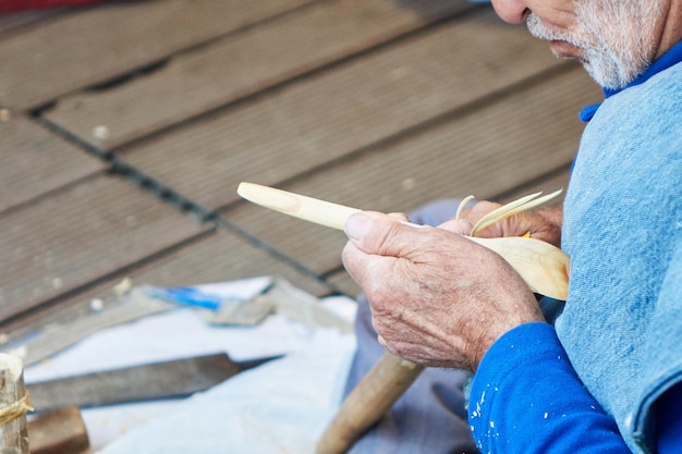 Foto gratuita il vecchio artigiano scolpisce da un cucchiaio di legno istanbul turchia