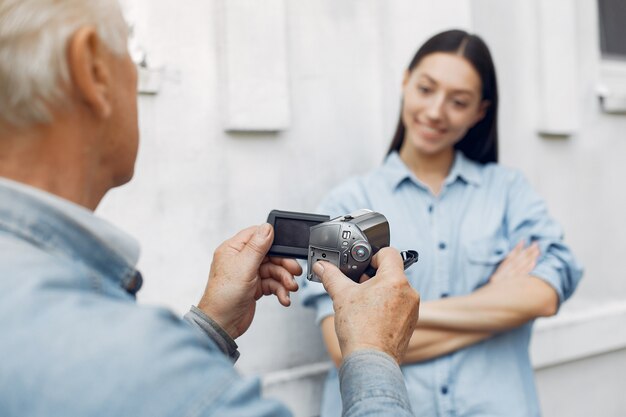 Old man filming his granddaughter