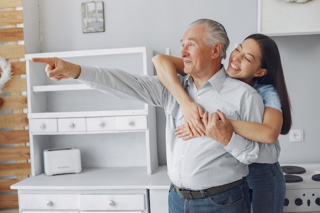 Old man in a kitchen with young granddaughter