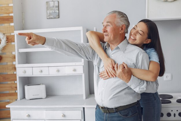 Old man in a kitchen with young granddaughter