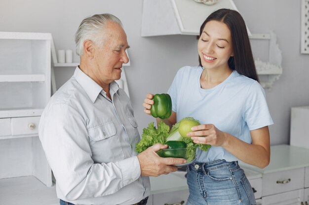 Old man in a kitchen with young granddaughter