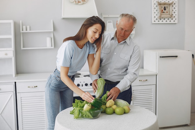 Old man in a kitchen with young granddaughter