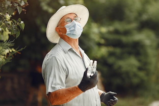 Foto gratuita uomo anziano in una mascherina medica. l'uomo nel parco. tema coronavirus.