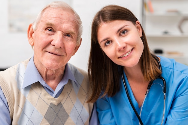 Old man and nurse looking at the camera