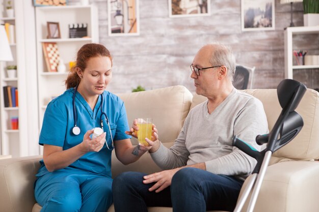 Free photo old man in nursing home helped by female doctor to take his medicine.