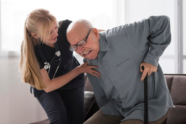 Old man in pain helped by nurse