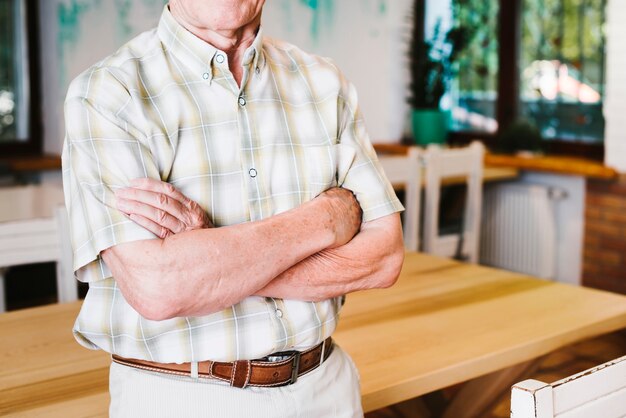 Old man standing crossing arms