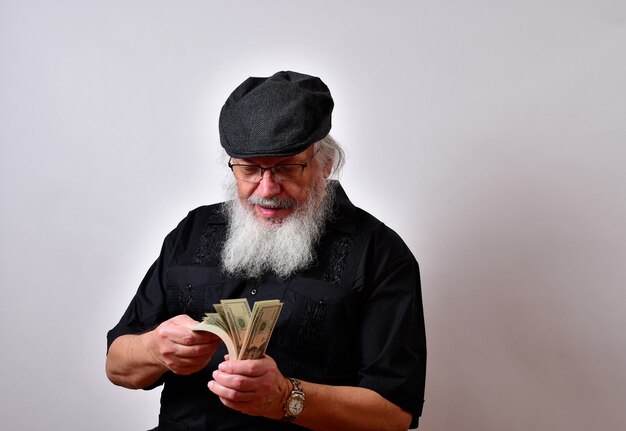 An old man with a beard counting his money