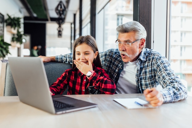 タブレットを使用して子供にビデオ通話をする孫娘と老人。