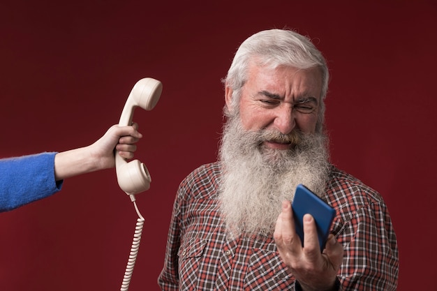 Old man with new and old telephone