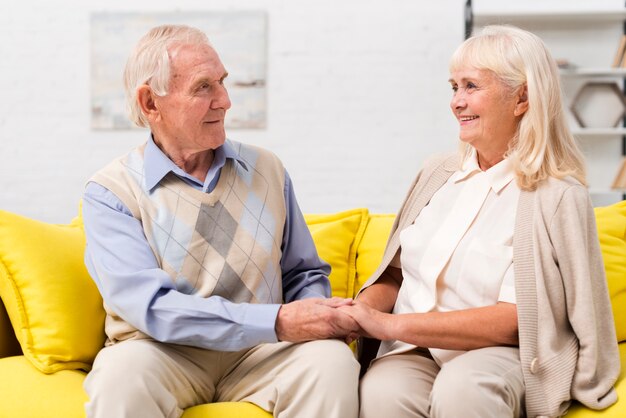 Old man and woman talking on yellow sofa