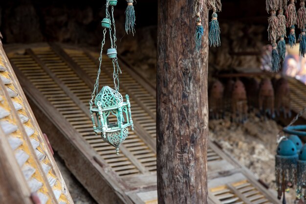 An old metal lamp or candlestick hangs at a flea market.