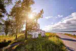 Free photo old orthodox church at village. summer view with floral meadow. sunny day, blue sky with clouds.