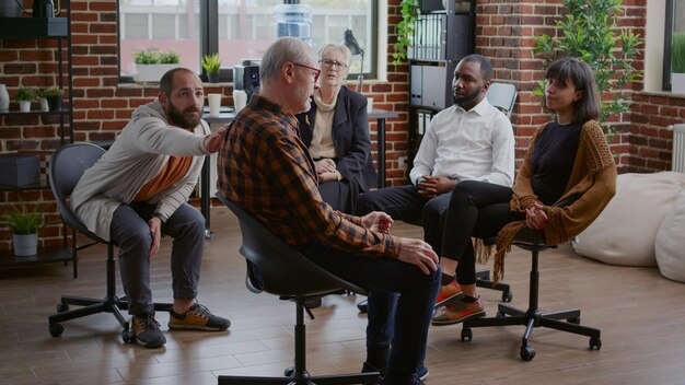 Old person complaining about alcohol addiction with people and therapist at aa meeting. Senior man talking about depression and anxiety with patients in circle at rehab therapy session.