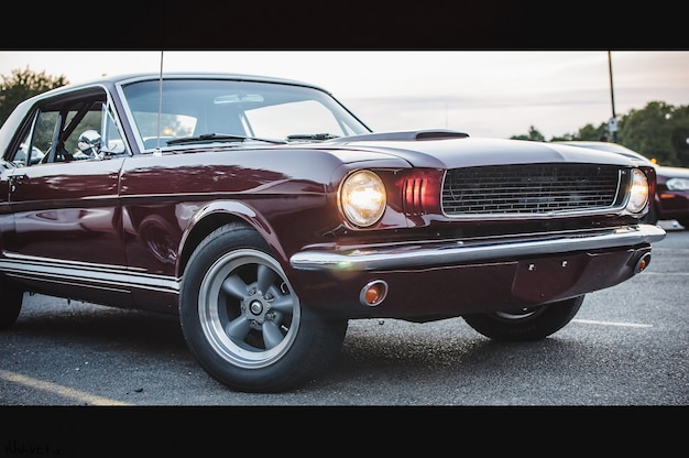 Old red American car stands on the street in the evening