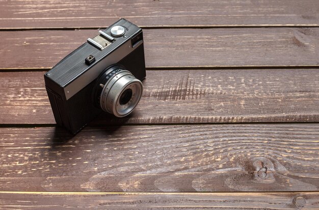 Old retro camera on wooden table background