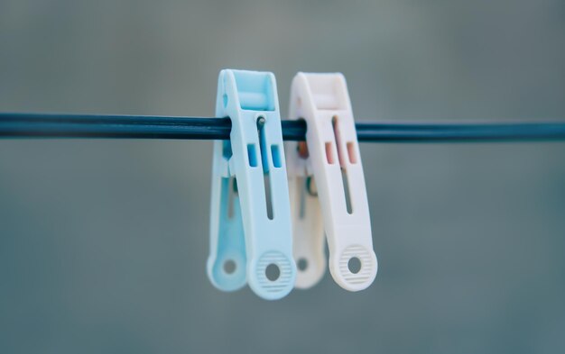 Old rough blue and pink clothes peg on a rope wire blurred background cloth clips on a washing line