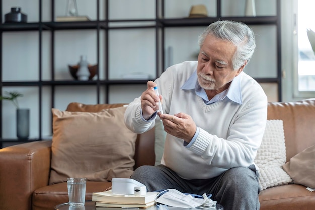 Il vecchio tampone nasale della mano maschile asiatica senior che testa i test rapidi da solo per il rilevamento del virus sars co2 a casa isola il concetto di quarantena