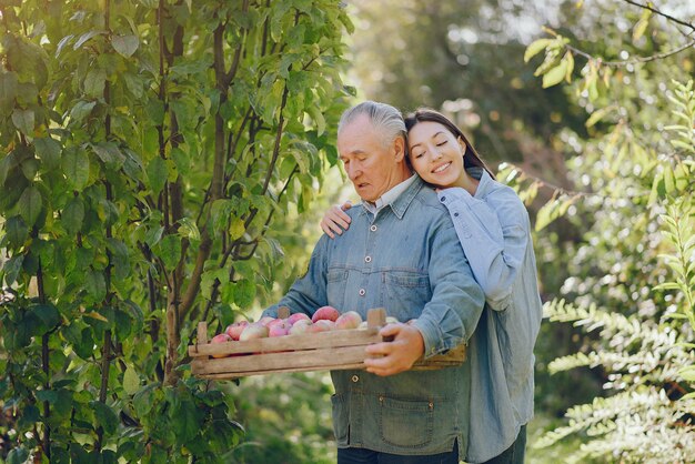 Old senior standing in a summer garden with harvest