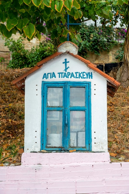 An old shrine on the street made of stone with icons inside in Skala Fourkas, Greece