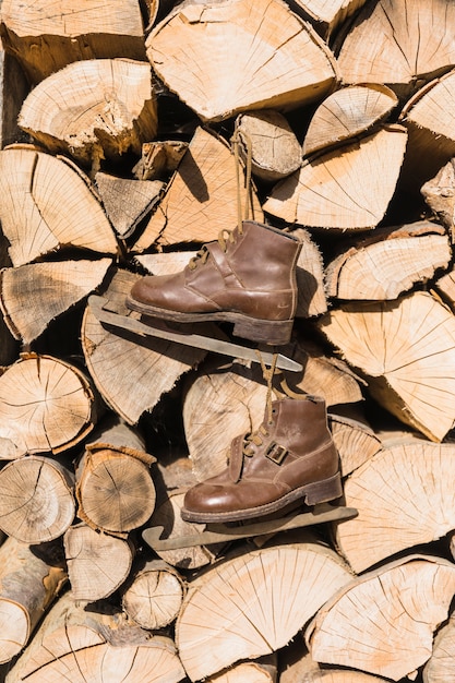 Old skates hanging on stack of firewood