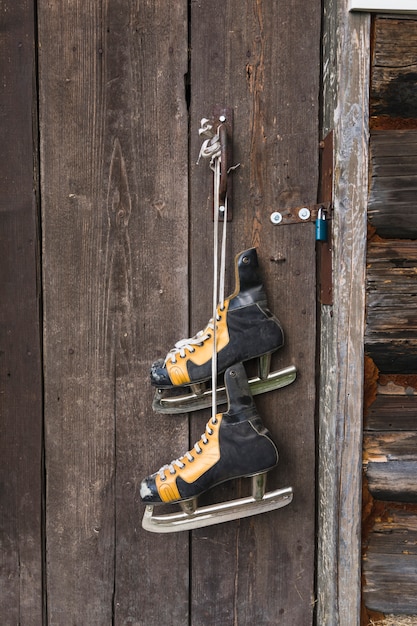 Old skates hanging on wood door 