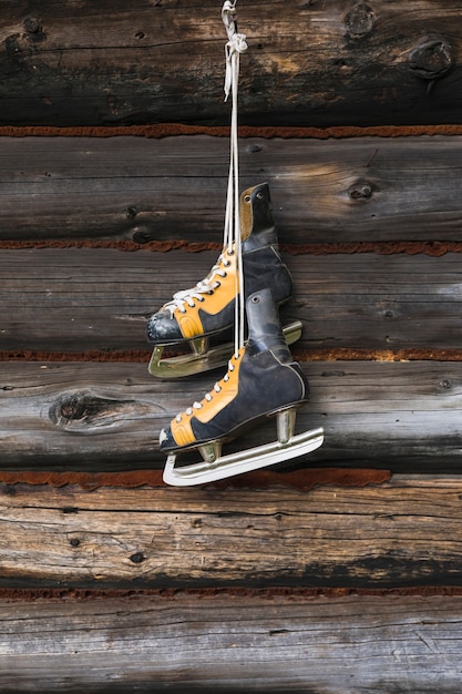 Old skates hanging on wooden wall