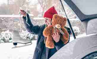 Free photo old skates and a teddy bear in the hands of a young woman in winter