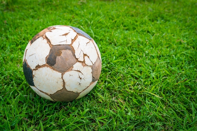 Old soccer ball on fresh spring green grass