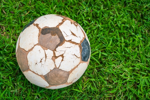 Old soccer ball on fresh spring green grass