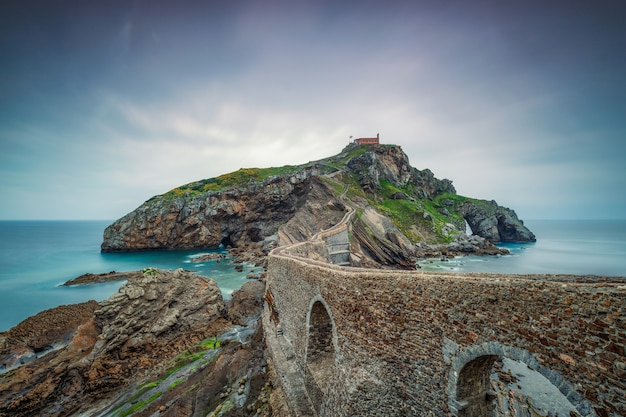 Old stone wall going over the ocean to an island