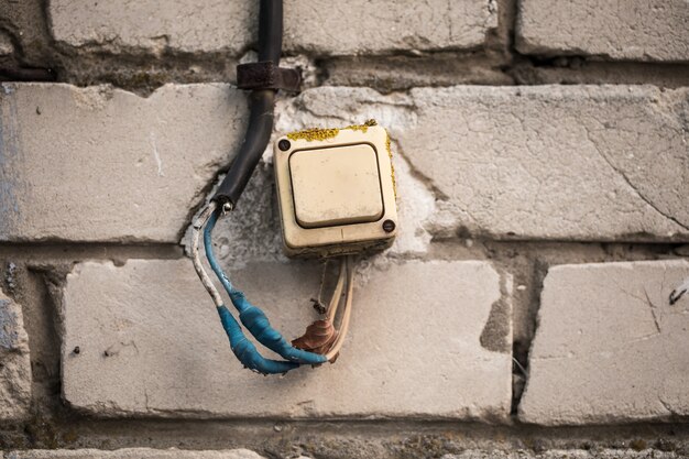 The old switch on the brick wall, twisted the blue tape.