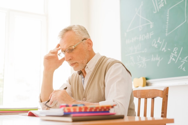 Vecchio insegnante che controlla i compiti in classe