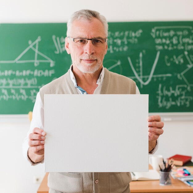 Old teacher showing clear sheet of paper 