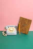 Free photo old telephone and book on wooden table