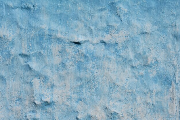 Old typical Mediterranean house with bright blue paint and old cracked plaster on the wall. Background or backdrop to decorate the space