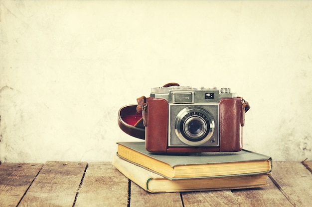 Old Vintage Camera on old books on Wooden Background. Old Vintage Holiday Concept.